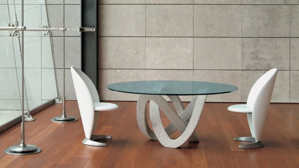 Tavolo rotondo di design con top in vetro e basamento in materiale granitico scolpito e bocciardato a mano Andromeda 72 di Reflex